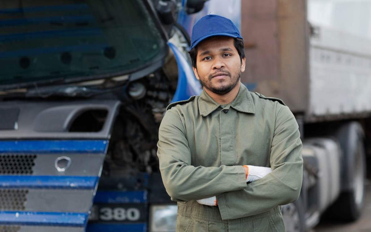 A truck driver standing in front of his truck